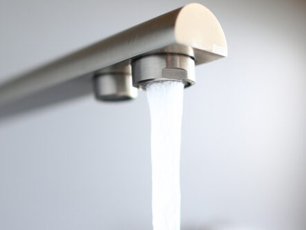 Close-up jet water from silver tap in kitchen